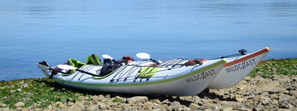 an inflatable boat on the shore of a lake