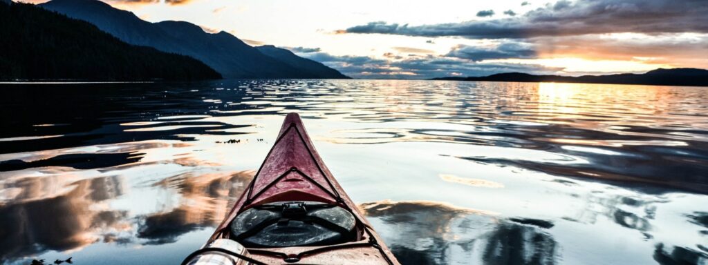 a red kayak is sitting on the water