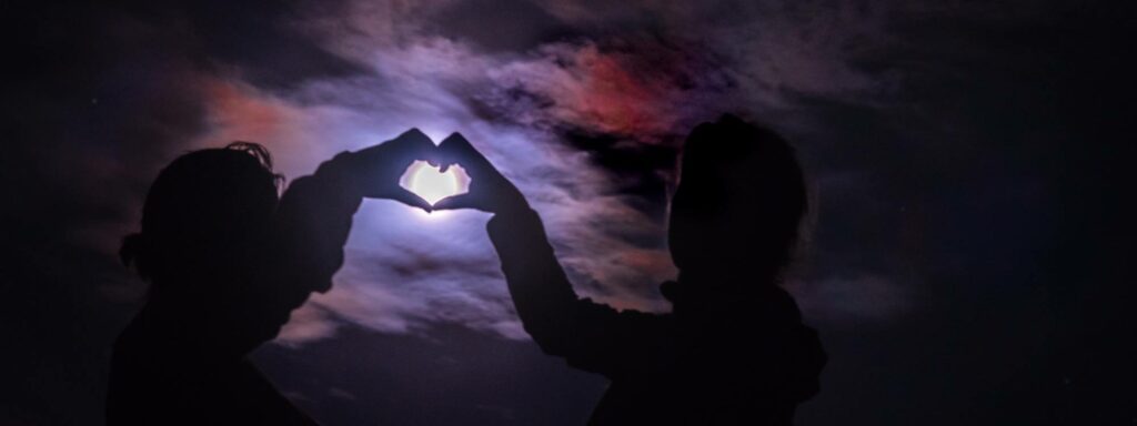 two people holding their hands up to the sky