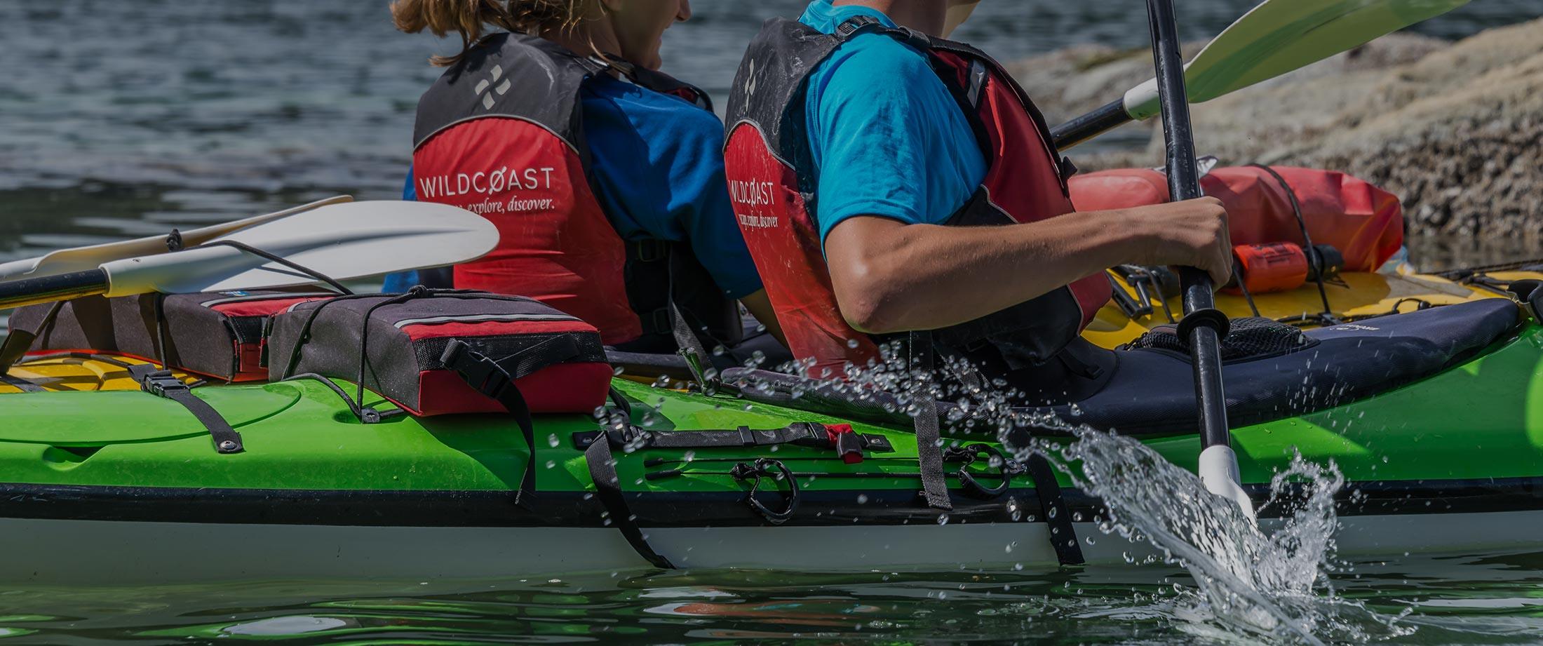 two people in a kayak paddling on the water