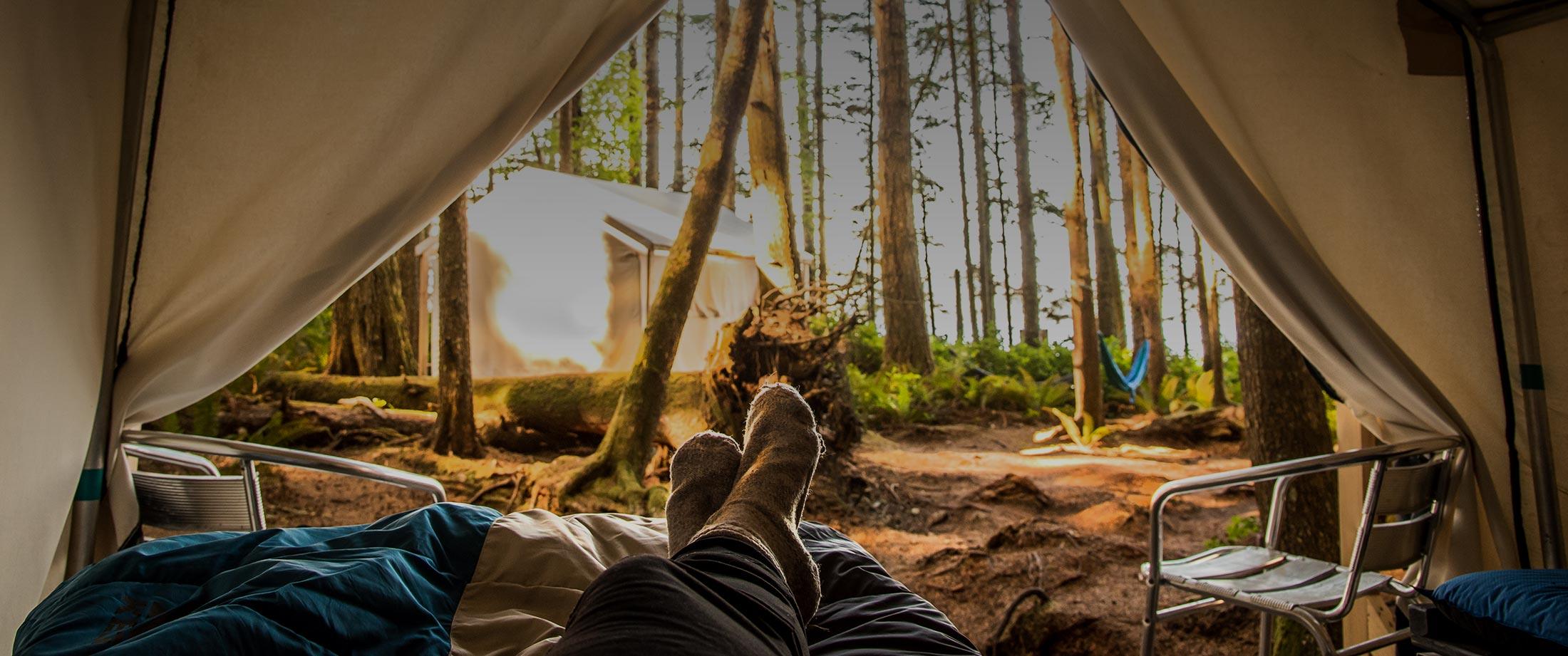 a person laying in a tent with their feet up