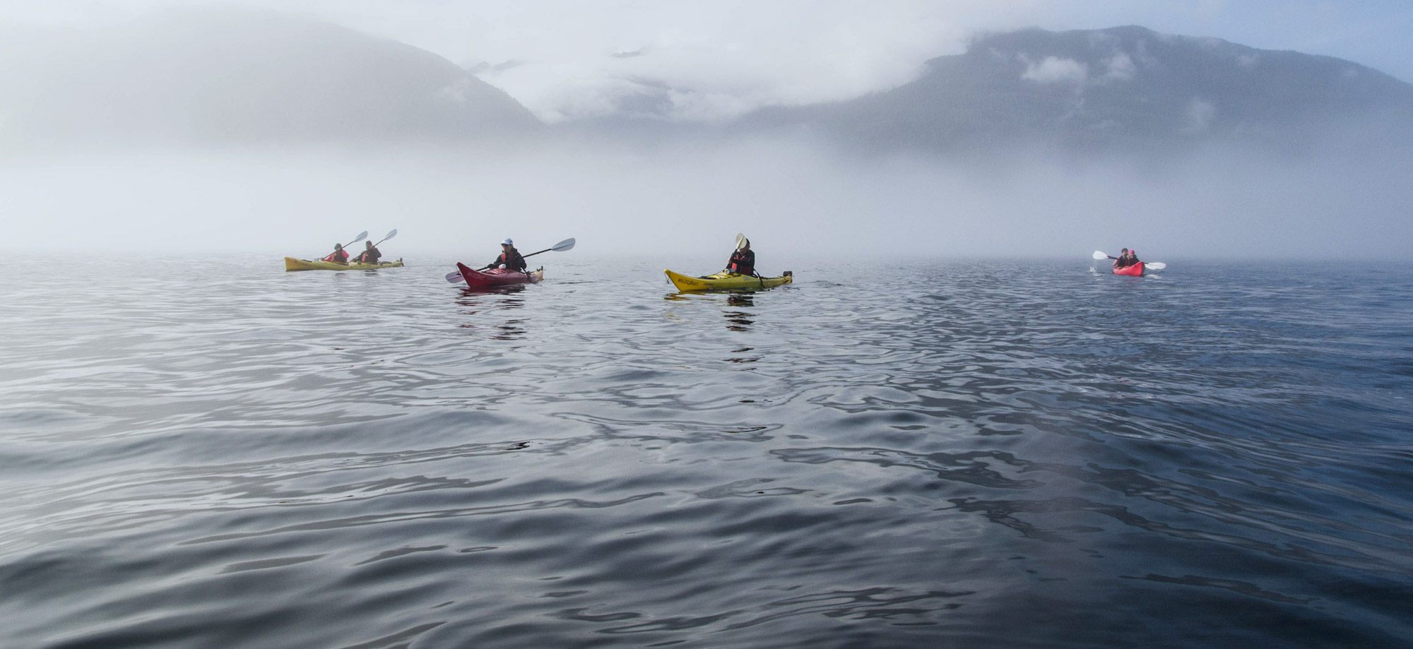 three people in canoes paddling on the water