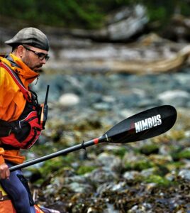 a man in an orange life jacket is paddling a kayak