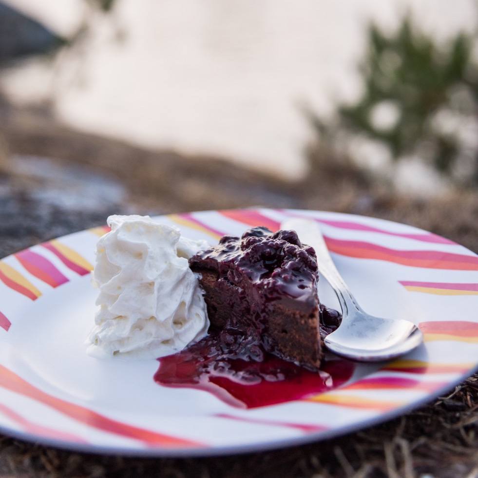 a piece of cake on a plate with ice cream