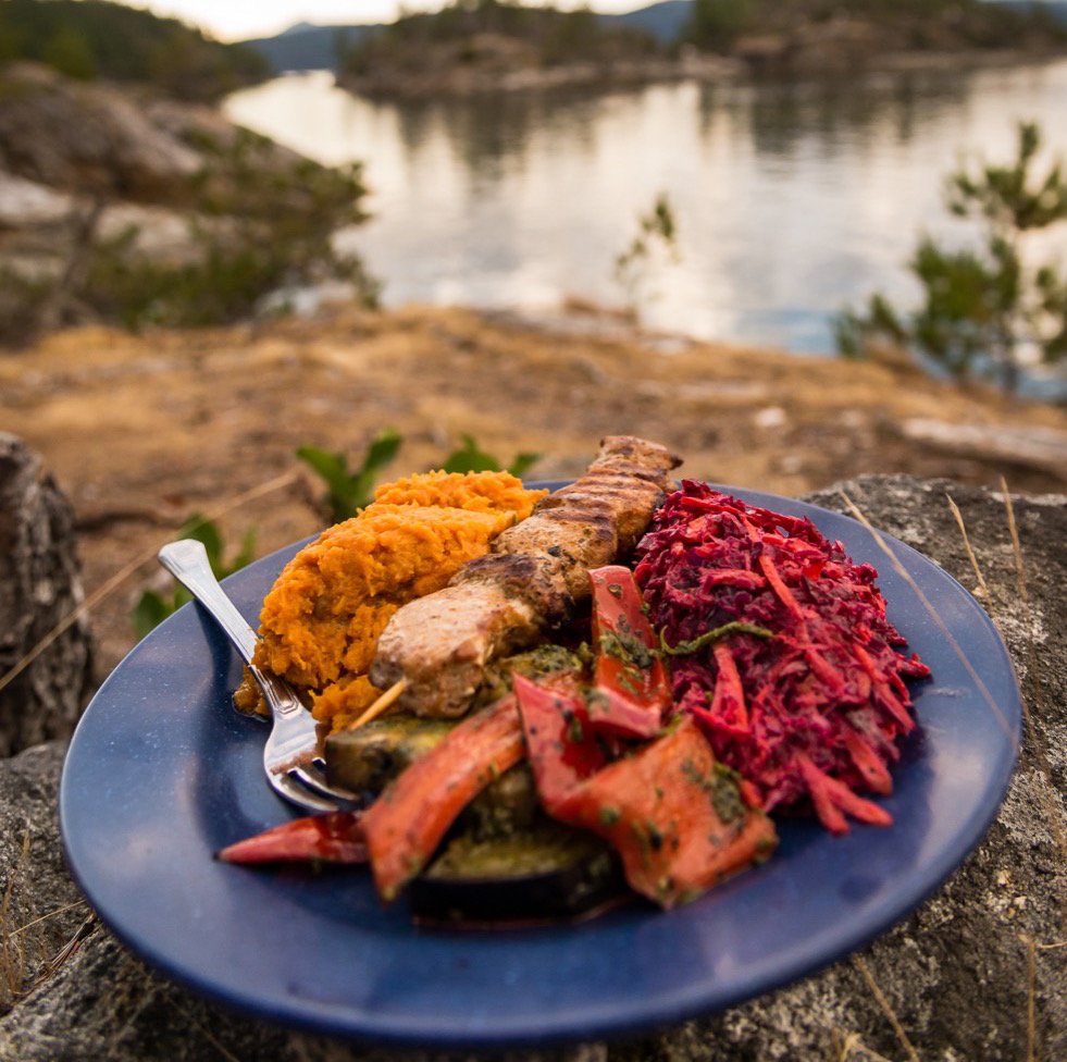 a plate of food with carrots, cabbage and meat