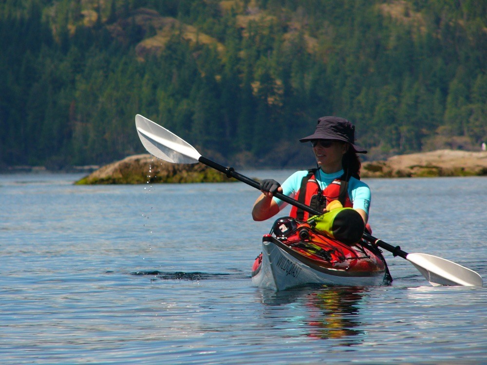 a woman is paddling her kayak on the water