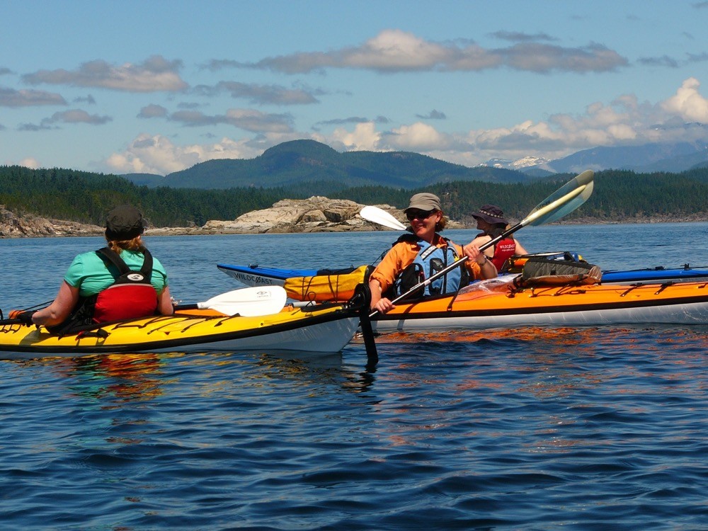 two people in kayaks paddling on the water