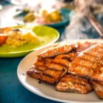 some food is on a white plate near other plates