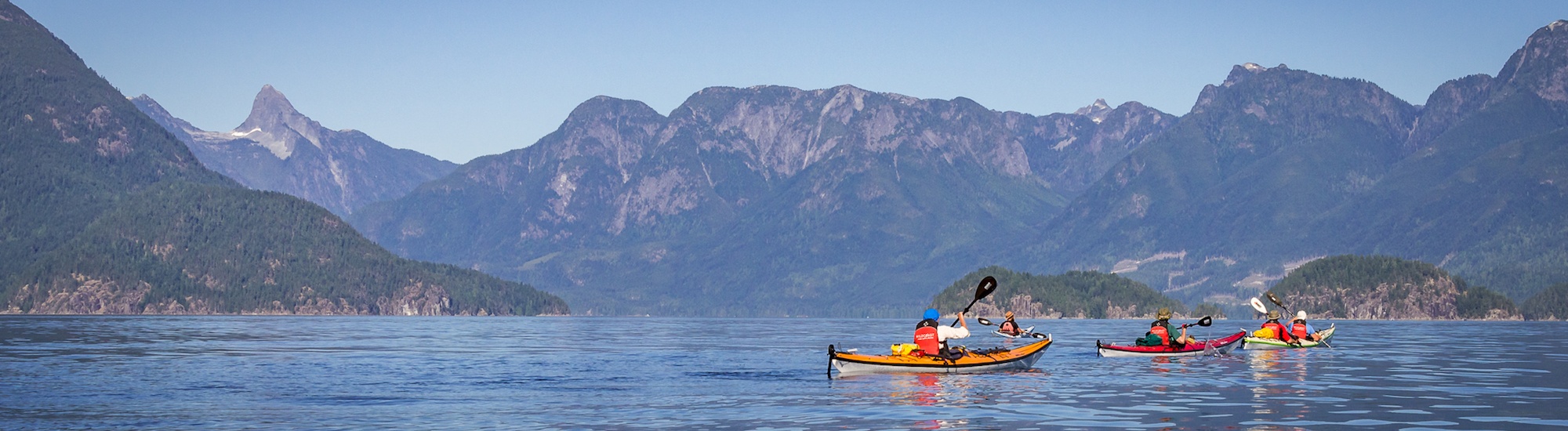 three people in canoes paddling through the water