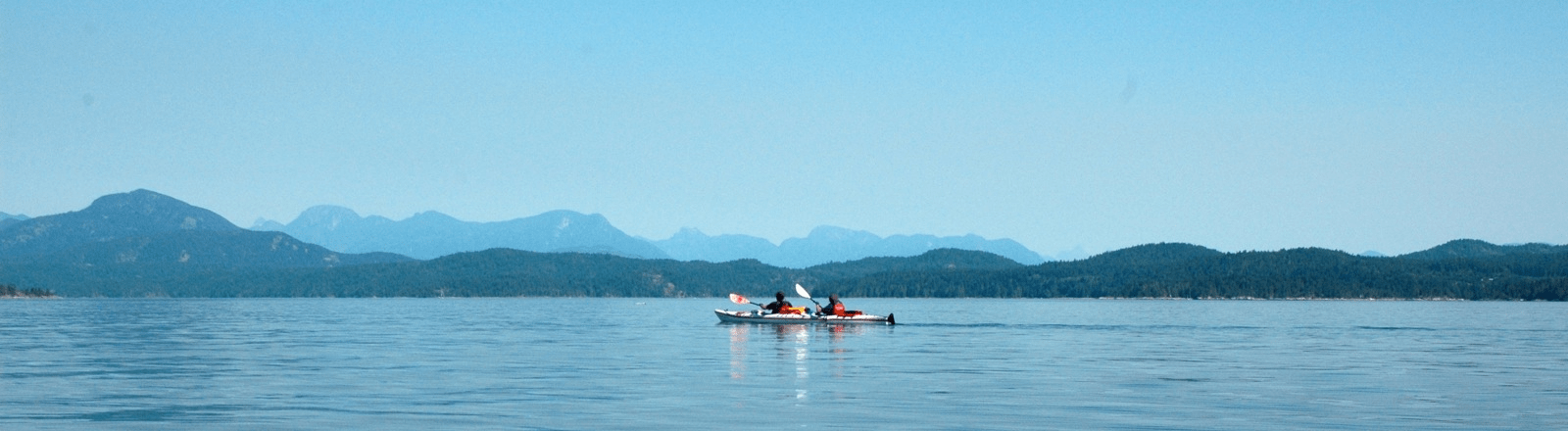 two people in a small boat on the water