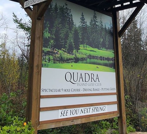 a sign for quadra near a wooded area