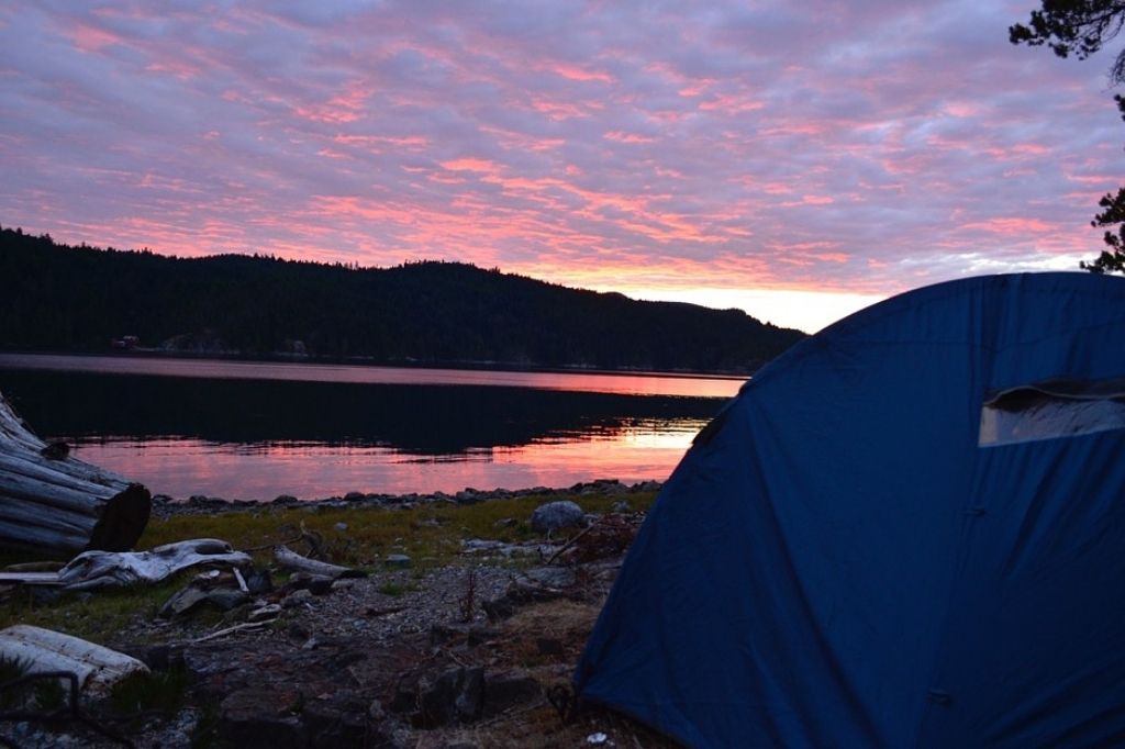 a blue tent sitting on top of a grass covered field
